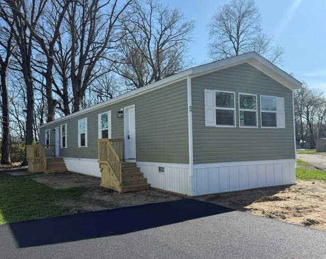 A newly set manufactured home on a freshly prepared lot, leveled and tied down by SetCo